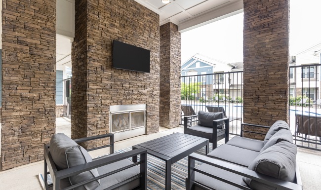 Outdoor lounge with fireplace and tv